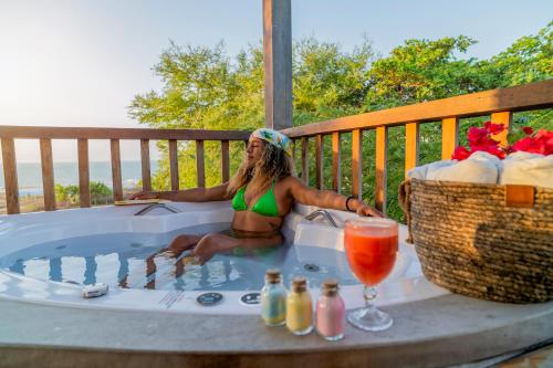 a woman sitting in a hot tub on a deck at Casa Suiça Brasileira in Jericoacoara