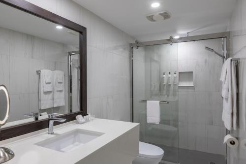 a bathroom with a sink and a toilet and a shower at Le Nouvel Hotel in Montréal