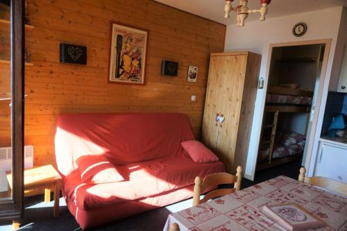 - un canapé rouge dans une chambre dotée d'un mur en bois dans l'établissement Résidence Plein Soleil Ii - studio cabine 4 personnes MAE-2850, à Orcières
