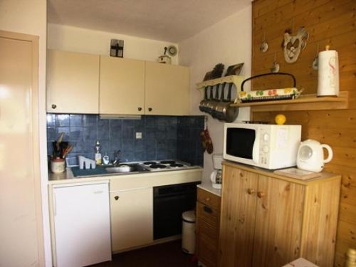 une petite cuisine avec un micro-ondes et un évier dans l'établissement Résidence Plein Soleil Ii - studio cabine 4 personnes MAE-2850, à Orcières