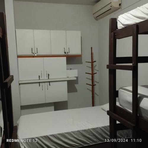 a bedroom with a bunk bed and white cabinets at Rô Hostel Cabo Branco in João Pessoa