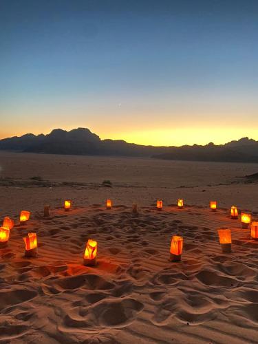a group of orange lanterns in the desert at Scarlet Luxury Camp Wadi Rum in Wadi Rum
