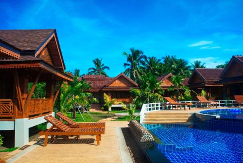 een villa met een zwembad en een resort bij Sangsawan Palace Khaolak Resort in Khao Lak