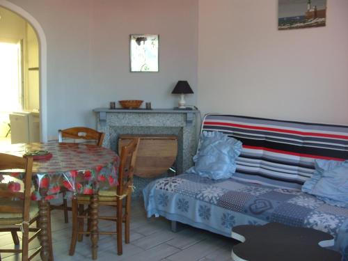 - un salon avec une table, un lit et une cheminée dans l'établissement maison atypique entre baie de somme et mers les bains, à Dargnies