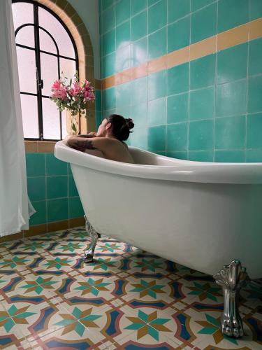 a woman laying in a bath tub in a bathroom at Nokal Exclusive Stay in Mexico City