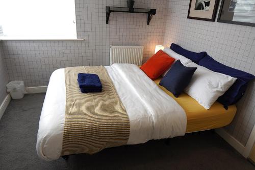 a bed with colorful pillows on it in a room at Luxury Rooms - Pick a Room - Free Parking & Kitchen Access, Near Etihad Stadium, The Coop Live & Piccadilly Station, Manchester in Manchester