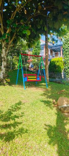 a playground in a yard next to a tree at Karapuzha Water Scapes in Wayanad