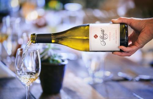 a person pouring a bottle of wine into a glass at Allegretto Vineyard Resort Paso Robles in Paso Robles