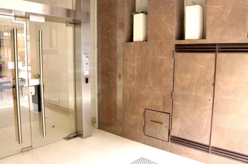 Un vestíbulo con un ascensor de cristal con dos luces. en Amplio monoambiente con piscina, en Buenos Aires
