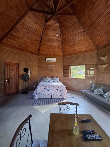 a bedroom with a bed and a table in a room at Hospedagem Casa do Chapéu Caparaó in PatrimÃ´nio da Penha
