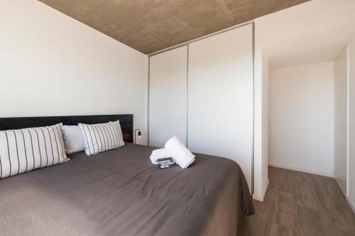 a bedroom with a large bed with white walls at Top Rentals Nuñez in Buenos Aires