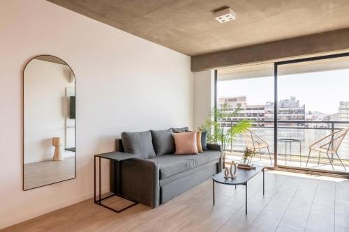 a living room with a couch and a large window at Top Rentals Nuñez in Buenos Aires