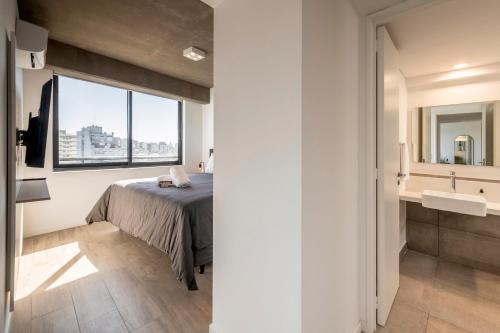 a bedroom with a bed and a sink and a window at Top Rentals Nuñez in Buenos Aires