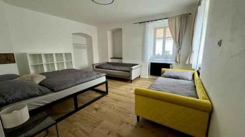 a bedroom with a bed and a couch and a chair at Family Apartments Černice in Mojné