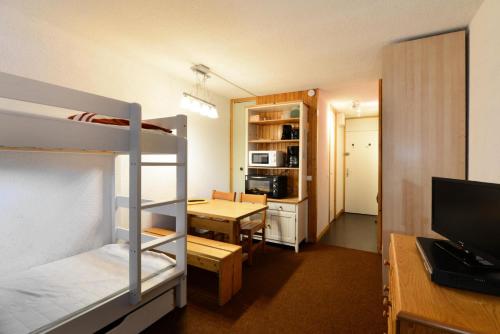 Cette chambre dispose de lits superposés et d'un bureau avec une table. dans l'établissement Résidence La Maison Tresallet - Studio au coeur de la station MAE-9324, à Aime La Plagne