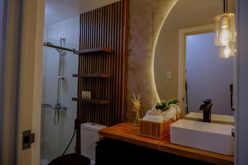 a bathroom with a white sink and a mirror at Kozen at Azure North Pampanga in San Fernando