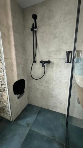 a shower in a bathroom with a shower head at Family Apartments Černice in Mojné