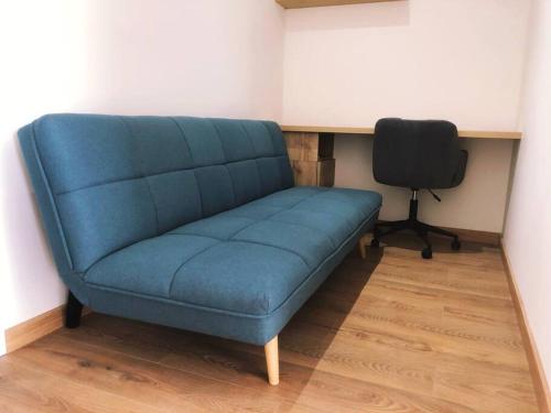 a blue couch in a room with a desk and a chair at Apartment with Panoramic & Ocean View in Lima