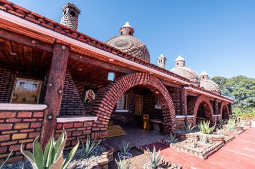 a brick building with an archway in a courtyard at HOTEL & SPA LOS AGAVES Tepotzotlán in Las Ánimas