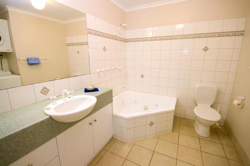 La salle de bains est pourvue d'un lavabo et de toilettes. dans l'établissement Lorne Ocean Sun Apartments, à Lorne