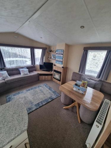 an rv living room with a couch and a table at 118 holiday resort unity pet friendly caravan brean sands in Berrow