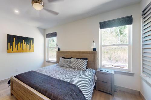 a bedroom with a bed and two windows at Rendezvous Retreat in Fraser