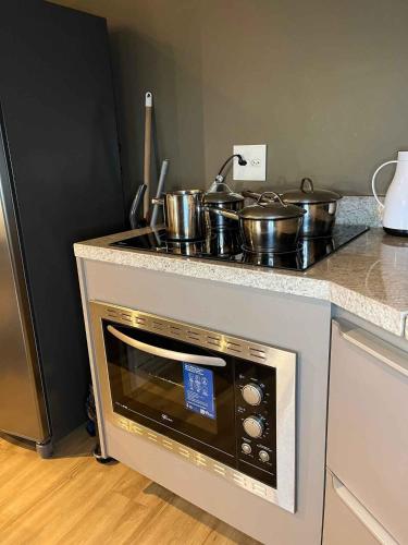 a kitchen with a stove with pots and pans on it at LK Santo Agostinho 2 in Belo Horizonte