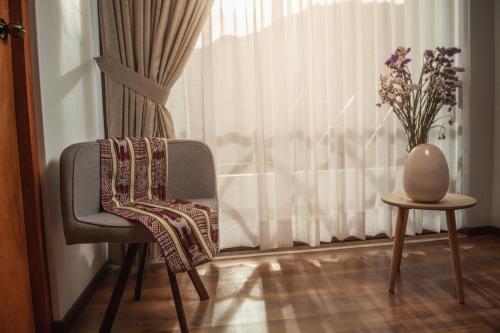 a chair and a vase sitting next to a window at Flores de la Villa in Huaran