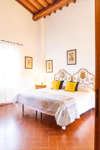 a bedroom with a large bed with yellow pillows at Borgo Il Poggio Agriturismo in Montaione