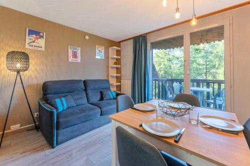 un salon avec un canapé bleu et une table dans l'établissement Résidence Le MÉale - Studio rénové 4 personnes aux Orres 1650 MAE-9341, aux Orres