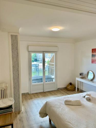 une chambre avec un lit et une porte coulissante en verre dans l'établissement Loft avec parking centre Tours et bord du Cher Loire Valley, à Tours