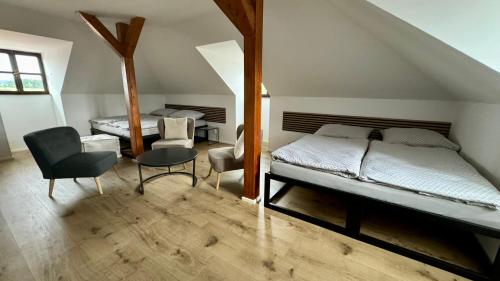 a bedroom with two beds and a table and chairs at Family Apartments Černice in Mojné