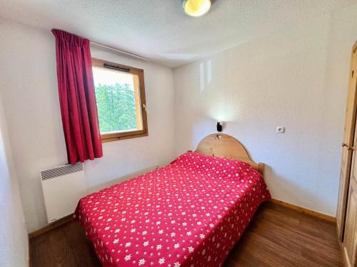 une petite chambre avec un couvre-lit rouge et une fenêtre dans l'établissement Résidence L'ecrins Des Neiges - T3 proche des pistes - L'Ecrin des neiges MAE-1801, à Vars