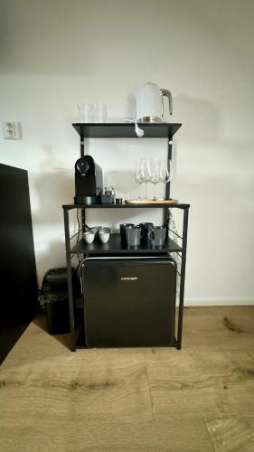 a shelf with cups and glasses on a stove at Family Apartments Černice in Mojné