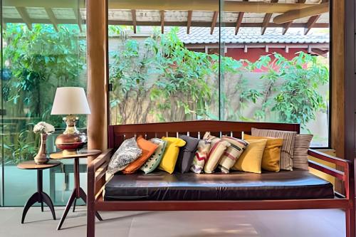 a bench with a bunch of pillows on it at Casa Charme no Centro de Bonito - Condomínio Eco Bonito in Bonito