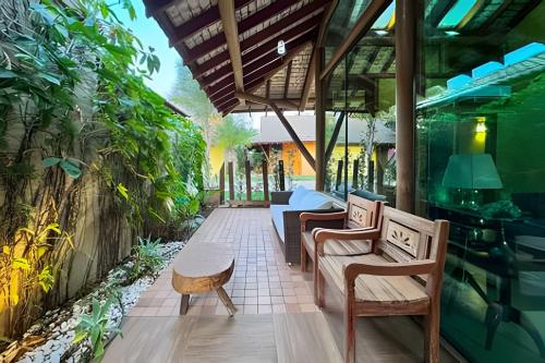a patio with chairs and a table and plants at Casa Charme no Centro de Bonito - Condomínio Eco Bonito in Bonito