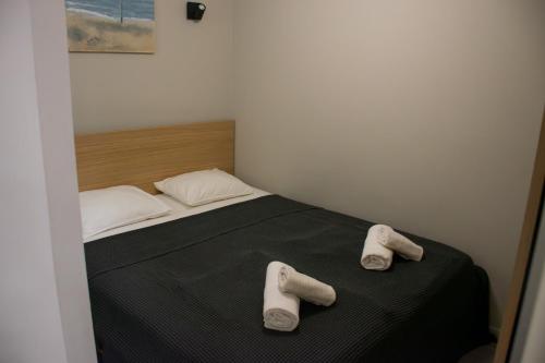 Un dormitorio con una cama con dos pares de pantuflas encima. en Levstik apartment, en Piran