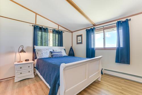 een slaapkamer met een bed en blauwe gordijnen bij Serene Lake Huron Gem with Fishing Dock! in De Tour Village