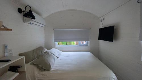 a small room with a bed and a window at Las Cabañas de City Bell - El Tilo in City Bell