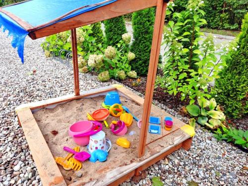 a miniature sandbox with toys in the sand in a garden at Pokoje po drodze w Barczewie in Barczewo