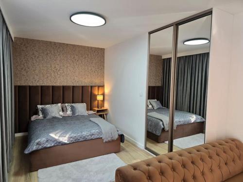 Un dormitorio con una cama grande y un espejo. en Apartament Bulvary nad Odrą, en Szczecin