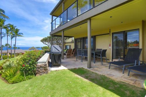 a patio with chairs and a grill next to a house at Elua 2011 in Wailea