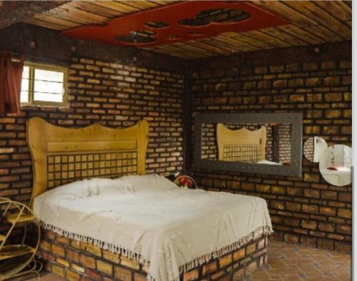 a brick bedroom with a bed in a brick wall at HOTEL & SPA LOS AGAVES Tepotzotlán in Las Ánimas