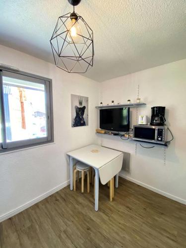 une petite cuisine avec une table et une fenêtre dans l'établissement Résidence Kandahar - Agréable studette au centre de la station MAE-5461, à Vénosc