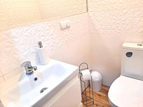 a bathroom with a sink and a toilet at Pokoje po drodze w Barczewie in Barczewo