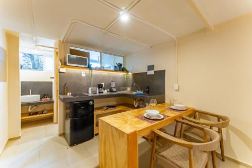 a small kitchen with a wooden table and chairs at Casa Jicama in Cancún