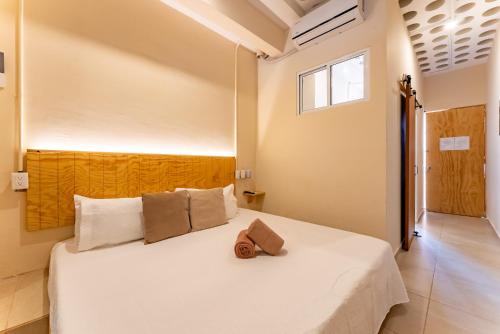 a bedroom with a white bed and a window at Casa Jicama in Cancún
