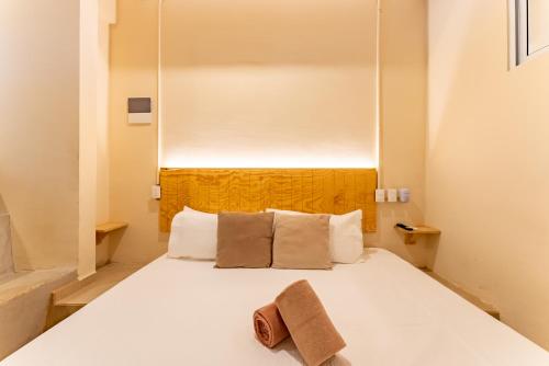 a bedroom with a white bed with a towel on it at Casa Jicama in Cancún