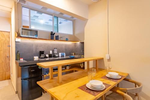 a kitchen with a wooden table and a counter top at Casa Jicama in Cancún