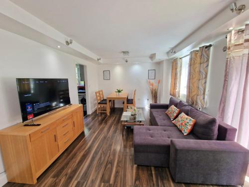 a living room with a couch and a flat screen tv at Contractors 2 Bed Apartment in Stevenage By White Orchid Property Relocation in Stevenage